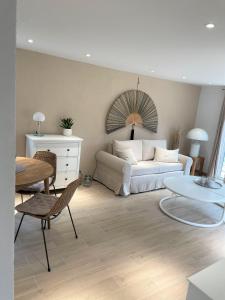 a living room with a white couch and a table at Moderner Bungalow im Seebad Bansin, 200 Meter zum Strand in Bansin