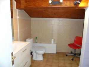 łazienka z toaletą i czerwonym krzesłem w obiekcie Logement chez l'habitant! w mieście Condéon +3 zdjęcia