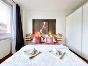 1 dormitorio con 1 cama con 2 toallas en Jana's apartment, free parking, en Praga