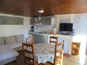 ein Wohnzimmer mit einem Tisch, Stühlen und einem Sofa in der Unterkunft Logement chez l'habitant! in Condéon