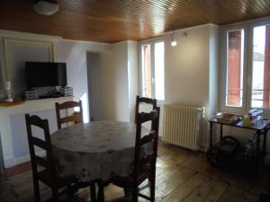 ein Esszimmer mit einem Tisch, Stühlen und Fenstern in der Unterkunft Logement chez l'habitant! in Condéon
