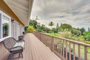 een veranda met 2 stoelen en een bank bij Hawaiian Retreat with Ocean Views in Captain Cook! in Papa Bay Estates