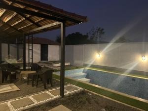 una casa con piscina por la noche en Serene Pool Villa, en Karumattampatti