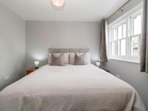 a bedroom with a large white bed with two windows at 19 Lion Street in Hereford