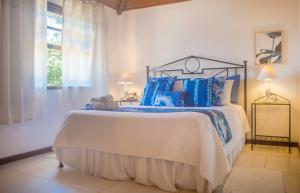 a bedroom with a large bed with blue pillows at Pousada do Namorado in Búzios