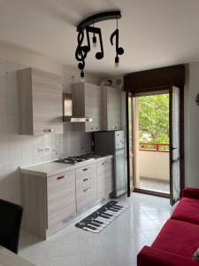 una cucina con armadi bianchi e un divano rosso di House of music near venice a Mogliano Veneto