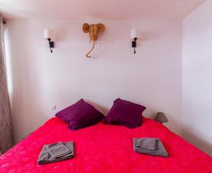 a bedroom with a red bed with a teddy bear on the wall at Appartement T4 central quartier Saint-Georges -Le Picomax- in Toulouse