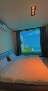 una camera da letto con un grande letto con una grande finestra di شالية لايت مون a Dammam