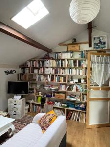 a living room filled with lots of books at La Chambre Du Voyageur in Soustons