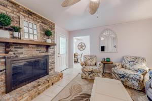 a living room with a fireplace and two chairs at Always an Optimist in Pensacola