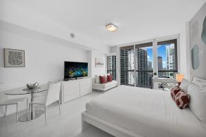 a white room with a bed and a table and a tv at Stylish Studio Icon, W Hotel Waterfront Building in Miami