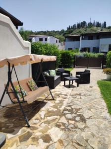 een patio met een schommel, een tafel en stoelen bij La Villetta di Rosa in Campofelice di Roccella