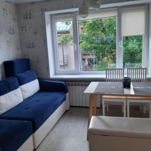 a living room with a blue couch and a table at Home for your vacation 1-bedroom apartment in Narva-Jõesuu