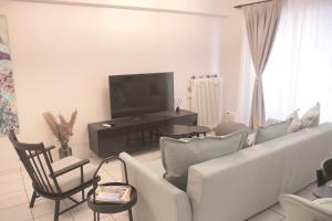 a living room with a couch and chairs and a television at Apartamento Central - La Amistad in Athens