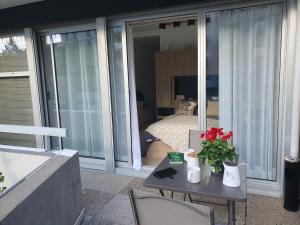 einen Balkon mit einem Tisch mit Blumen und ein Schlafzimmer in der Unterkunft CLUB APPART in Vernon