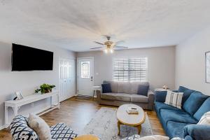 a living room with a blue couch and a ceiling fan at 3rd Avenue Oasis in Myrtle Beach