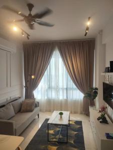 un soggiorno con divano e ventilatore a soffitto di Sakifa's Home @ Troika Kota Bharu a Kota Bharu