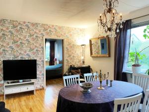 - un salon avec une table et une télévision dans l'établissement Well-equipped holiday home in Varnamo, à Värnamo
