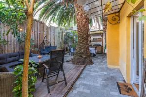 阿爾卡雄的住宿－La Maison des Huîtres，一个带桌子和棕榈树的庭院