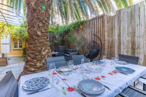 una mesa con platos y vasos en el patio en La Maison des Huîtres, en Arcachon