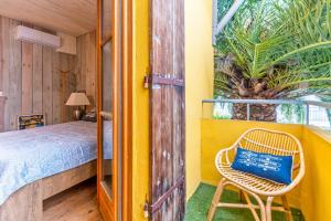 een gele kamer met een bed en een stoel bij La Maison des Huîtres in Arcachon
