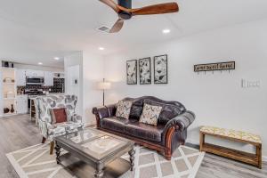 a living room with a leather couch and a ceiling fan at Corpus Christi Charm in Corpus Christi