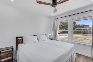 a white bedroom with a bed and a window at Corpus Christi Charm in Corpus Christi