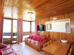 a living room with a red couch and a table at Appartement Tignes, 2 pièces, 5 personnes - FR-1-502-532 in Tignes