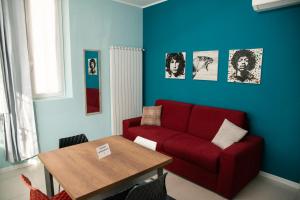uma sala de estar com um sofá vermelho e uma mesa em Casa Fulvia em Rozzano