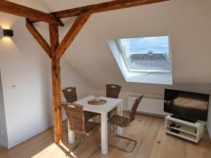 ein Esszimmer mit einem Tisch und Stühlen sowie einem TV in der Unterkunft Wohnung (Studio) in Hattingen an der Ruhr in Hattingen