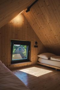 1 dormitorio con ventana en una cabaña de madera en PRIMÁTOR CAMPING RESORT LITOMYŠL en Litomyšl
