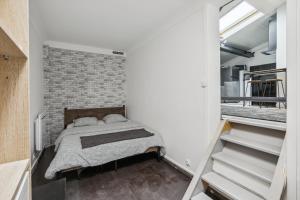 Schlafzimmer mit Ziegelwand und Bett in der Unterkunft Loft Paisible à Argenteuil / La défense/Beam in Argenteuil