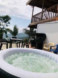 a large tub filled with water next to a grill at Hermosa casa finca en Medellín con jacuzzi ! in Medellín