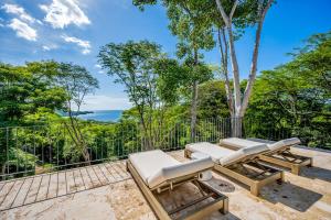 d'une terrasse avec des chaises longues et une vue sur la forêt. dans l'établissement Jungle Sanctuary, à El Jobo