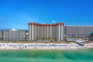 a group of people on a beach in front of a hotel at Shores of Panama #1921 by Nautical Properties in Panama City Beach