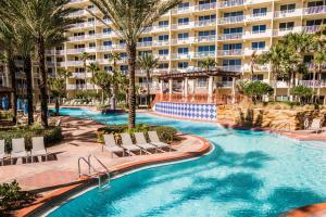 a resort swimming pool with chairs and a large building at Shores of Panama #1921 by Nautical Properties in Panama City Beach
