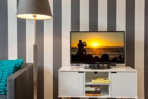Elle comprend une télévision à écran plat installée au-dessus d'un centre de divertissement blanc. dans l'établissement Woge2 Appartement 10, à Borkum