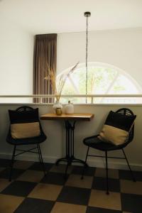 uma mesa e duas cadeiras num quarto com uma janela em Puur Mechelen em Mechelen
