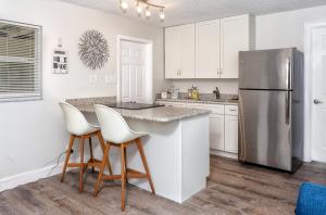 a kitchen with white cabinets and a stainless steel refrigerator at 1034 3rd Ave SW Unit B in Largo