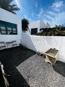 ein weißes Haus mit einem Tisch und Stühlen davor in der Unterkunft Apartamento en el centro de Lanzarote in Tiagua