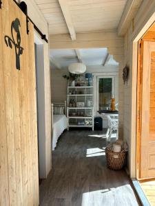 Lyminster的住宿－Driftwood Dreams Garden Cabin，房屋的走廊,带桌子的房间
