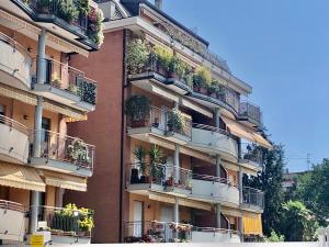 un edificio de apartamentos alto con macetas en los balcones en monica Casa Vacanza en Busto Arsizio