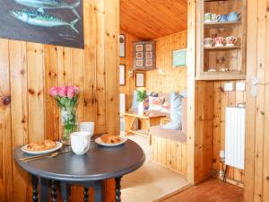 mały stolik w pokoju z drewnianymi ścianami w obiekcie Kestrel w mieście Seaton
