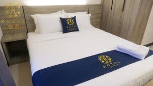 a bed with a blue and yellow pillow on it at Royal Suites Studio 15th Floor - Citra Plaza Nagoya Apartment in Nagoya