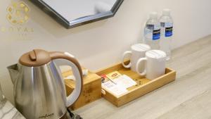 a tray with cups and bottles of water on a counter at Royal Suites Studio 15th Floor - Citra Plaza Nagoya Apartment in Nagoya