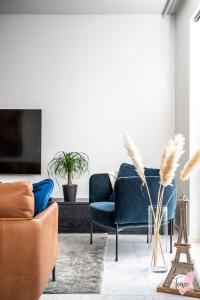 salon z niebieską kanapą i krzesłami w obiekcie Elegant apartment in Oulu w mieście Oulu