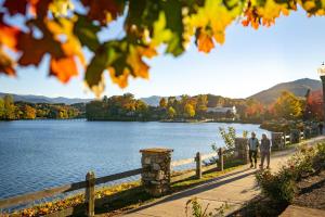 2 personnes marchant le long d'un sentier à côté d'un lac dans l'établissement Armstrong House & Apartment, à Lake Junaluska