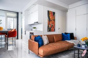salon z brązową kanapą z niebieskimi poduszkami w obiekcie Elegant apartment in Oulu w mieście Oulu