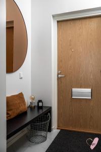Łazienka z drewnianymi drzwiami i lustrem w obiekcie Elegant apartment in Oulu w mieście Oulu