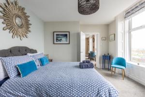 a bedroom with a bed with blue pillows and a mirror at BEACH VIEW - Amazing Sea Views in Lytham St Annes